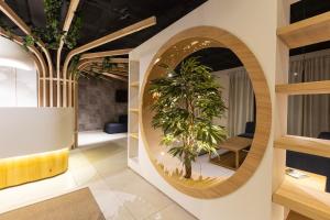 a circular mirror in a room with a plant at Aparthotel Nou Vielha in Vielha