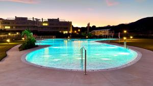 a large swimming pool with blue water at night at Luxury Golf Apartman in La Cala de Mijas Golf in Mijas