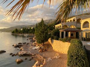 a building next to a body of water with trees at Villa Bavaria in Starigrad