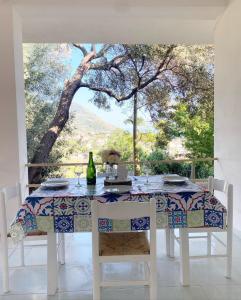 mesa de comedor con vistas a un árbol en Il Giardino Apartments - Peaceful atmosphere and free parking -, en Capo Vaticano