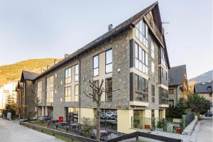 a large brick building with windows on a street at Aparthotel Nou Vielha in Vielha