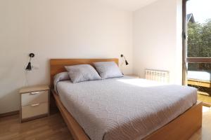 a bedroom with a bed and a large window at Aparthotel Nou Vielha in Vielha