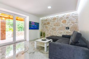 ein Wohnzimmer mit einer Couch und einer Steinwand in der Unterkunft Villa Old Stone in Gabonjin