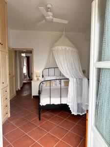une chambre avec un lit à baldaquin dans l'établissement Villa Demy, à Kardhianí