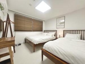 a bedroom with two beds and a piano at Check in Seoul Hongdae in Seoul