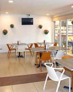 a restaurant with tables and chairs and a tv on the wall at Terra Bella Hotel Boutique in San Salvador
