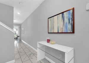 a white living room with a tv on a wall at 1569 SD - Spacious Champions Gate Retreat with Modern Amenities in Davenport