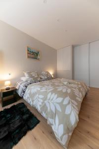 a bedroom with a large bed and a rug at L'Hotel des Postes - Appartement design en centre ville in Vichy