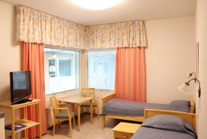 um quarto com 2 camas, uma secretária e uma mesa em Meri-Karina em Turku