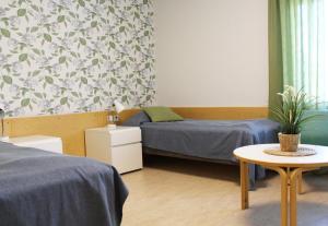 a bedroom with two beds and a table with a potted plant at Meri-Karina in Turku +31 photos