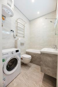 une salle de bain avec machine à laver et toilettes dans l'établissement ЖД вокзал Охматдет КПИ Политех В Черновола 30, à Kiev