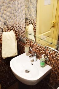a white sink sitting under a mirror next to a toilet at Agio Hotel in Kolochava