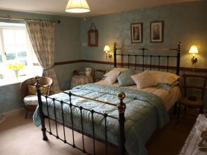 um quarto com uma cama grande e uma janela em High Wray Farm em Ambleside