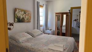 a bedroom with a bed with two towels on it at CASA POR do SOL in Tiradentes
