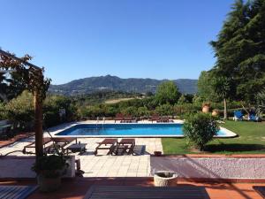 a swimming pool with tables and chairs in a yard at Quinta Verde Sintra - Casa de Campo in Sintra
