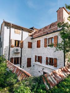 ein altes Gebäude mit Holzfenstern und einem Dach in der Unterkunft Art Hotel Galathea in Kotor