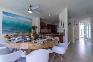 a dining room with a large wooden table and white chairs at Casa en Nuevo Vallarta in Nuevo Vallarta 
