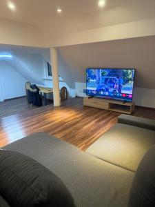 a living room with a large flat screen tv at KRAICHGAU # 3-ZKB mit 100qm voll ausgestattet im DG, Monteurzimmer, Self-Check-in in Ittlingen