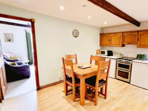 a kitchen with a wooden table and chairs at THE OLD WASH KITCHEN - Charming Character Cottage in Holmfirth, Yorkshire in Holmfirth