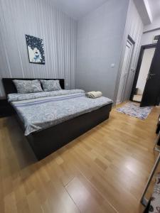 a bedroom with a bed and a wooden floor at Стаи за гости Пауза in Stara Zagora