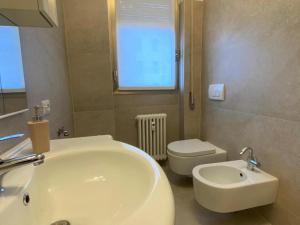 a bathroom with a white sink and a toilet at The Charme - Modern Apartment in Como with Balcony in Como