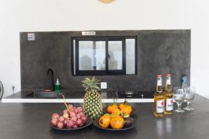two plates of fruit on a counter with bottles of alcohol at YO Villa Canggu in Canggu