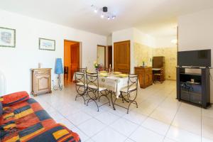 - un salon avec une cuisine et une table avec des chaises dans l'établissement La Caletta Corsa Apartments - 2 Camere, Terrazza Privata a 100m dal Mare, WiFi Fibra, à Linguizzetta