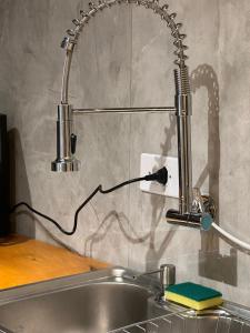 a kitchen sink with a faucet on the wall at Casa para temporada em Americana SP in Americana