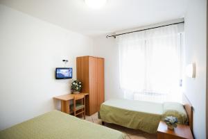 a bedroom with two beds and a window at Hotel La Toscana in Arezzo