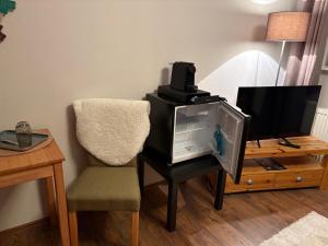 a living room with a tv and a chair at Pension Kulturhaus Niederau in Niederau
