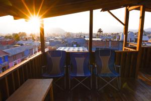 two blue chairs sitting on a balcony with the sun shining at Guadalupe B&B in San Cristóbal de Las Casas