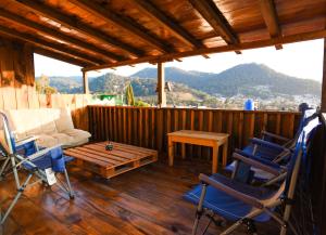 a porch with chairs and a couch and a table at Guadalupe B&B in San Cristóbal de Las Casas