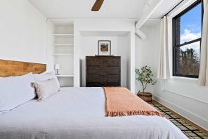 a white bedroom with a large bed and a window at Kasa Downtown Asheville in Asheville
