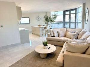 a living room with a couch and a table at Cardiff Skyline Penthouse Apartment Free Parking Sleeps 8 in Cardiff