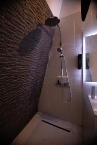 a bathroom with a shower and a brick wall at Love Room AMeuse&Vous in Hastière-par-delà +25 photos