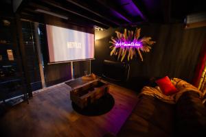 a living room with a couch and a projection screen at Love Room AMeuse&Vous in Hastière-par-delà