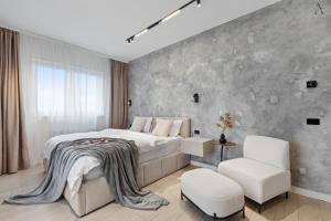 Un dormitorio con una cama grande y una silla. en Studio in Dimri Resident Ghencea, en Bucarest 20 fotos más