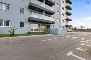 Un estacionamiento vacío frente a un edificio en Studio in Dimri Resident Ghencea, en Bucarest