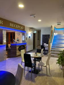 a restaurant with a table and chairs and stairs at Royal Hotel in Cserkeszőlő