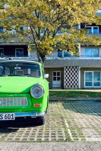a green car parked in front of a building at OSTLOFT - Plattenbauappartement in Eisenhüttenstadt in Eisenhüttenstadt