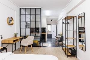 a room with a bed and a desk and chairs at B&M Suites in Thessaloniki