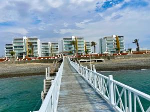 帕拉卡斯Duplex 1 Fila Vista Bahía Paracas - Sotavento 501 T3的建筑前方的一座水面上的木桥
