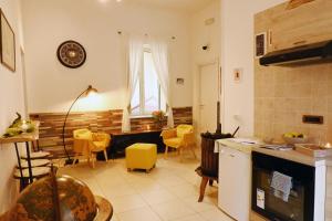 a kitchen and living room with a table and yellow chairs at Napoli Cityscape in Naples