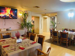 a restaurant with tables and chairs and a tv on the wall at Семеен хотел Балани in Gabrovo