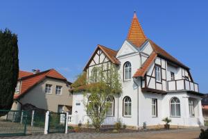 ein weißes und schwarzes Haus mit einem Turm in der Unterkunft Villa Mignon - Apartment Rot in Ostseebad Koserow