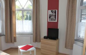 a living room with a tv and a chair at Villa Mignon - Apartment Rot in Ostseebad Koserow