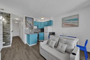 a living room with a couch and a kitchen at Bleu Oasis in Galveston