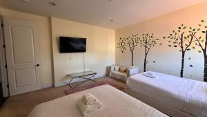 una camera con due letti e alberi sul muro di LA Dream Gem - Beautiful Home with Spa a Los Angeles