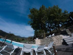 a patio with a table and chairs next to a swimming pool at RH Casas de Campo Design in Parada