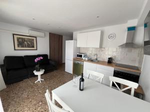 a kitchen and a living room with a white table at Zen mar; Confort & Relax centro Calafell in Calafell
